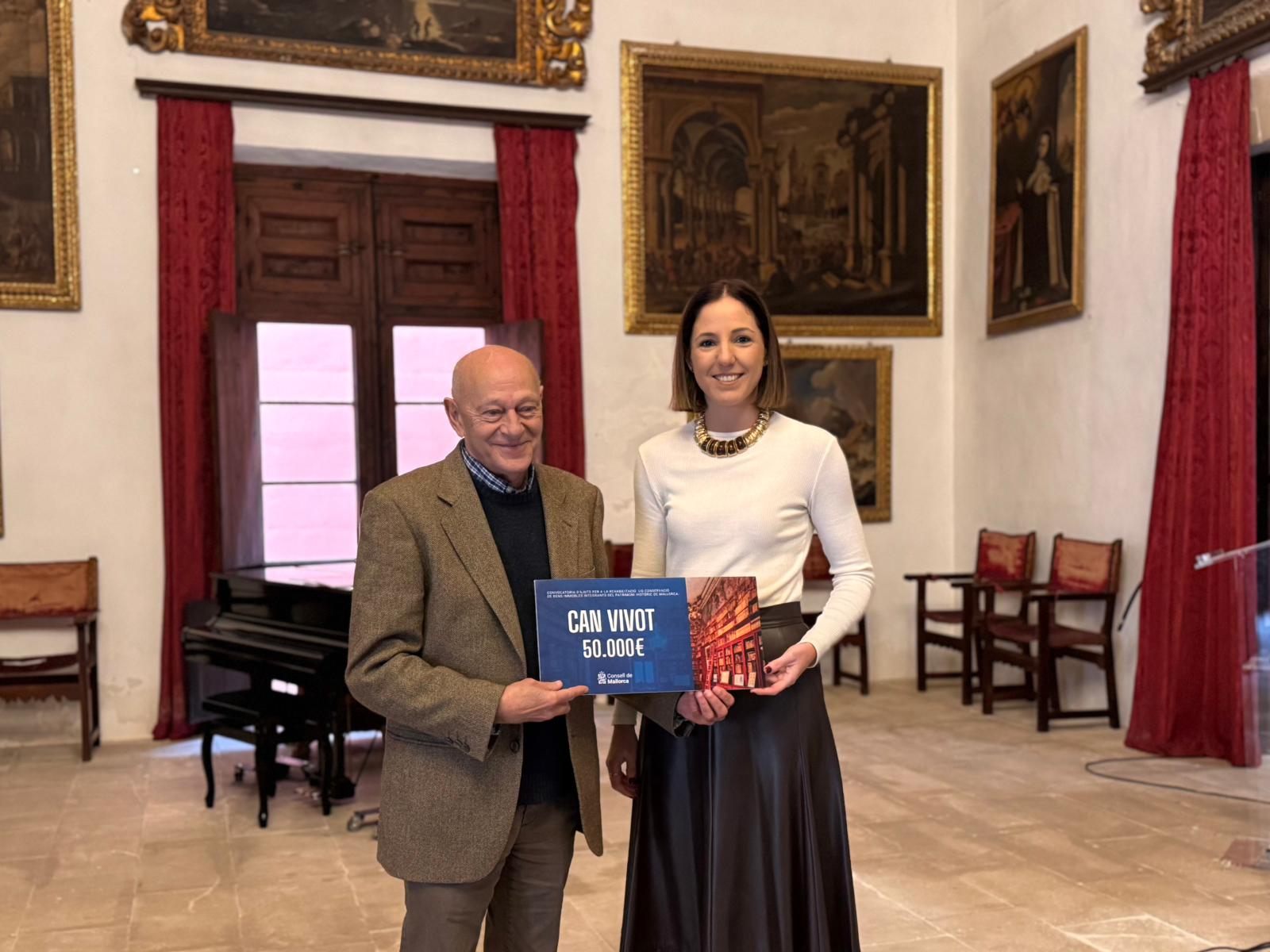 La consellera de Cultura i Patrimoni, Antònia Roca, lliura la subvenció al representant de Can Vivot.