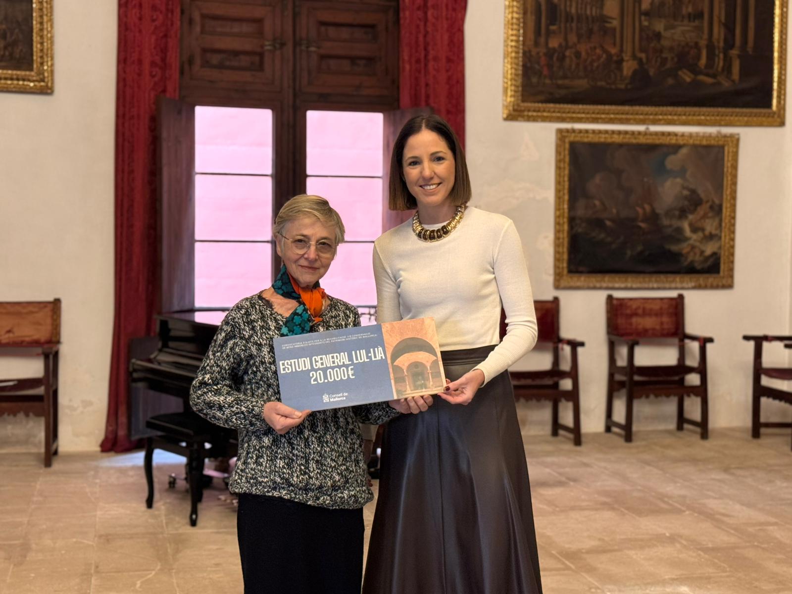 La consellera de Cultura i Patrimoni, Antònia Roca, lliura la subvenció a la representant de l'Estudi General Lul·lià.