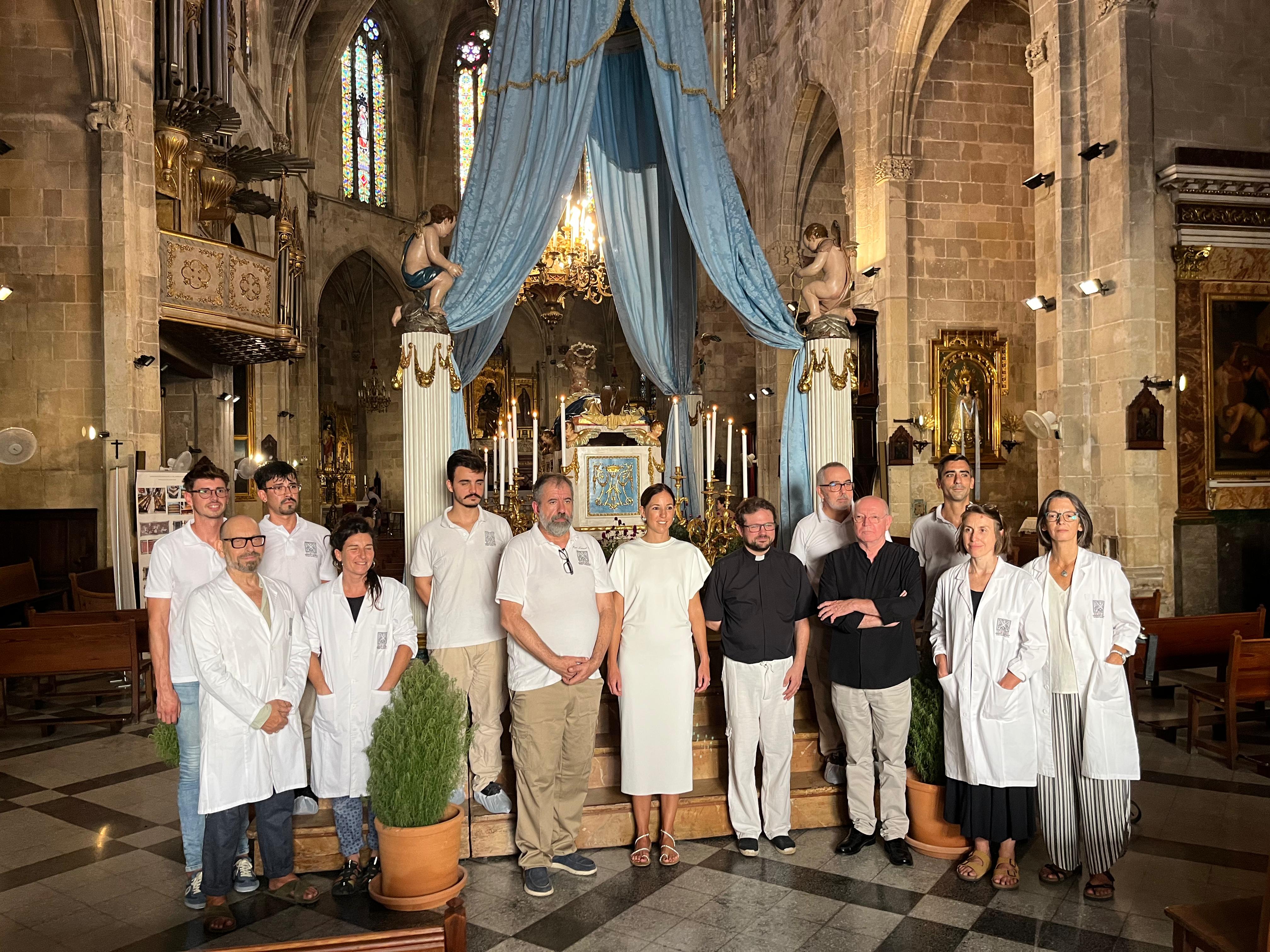 Imatge de la vicepresidenta del Consell de Mallorca y consellera de Cultura y Patrimoni, Antònia Roca; i el vicari episcopal del Patrimoni Històric i Cultural del Bisbat de Mallorca, Mn. Francesc Vicens amb l'equip restaurador.